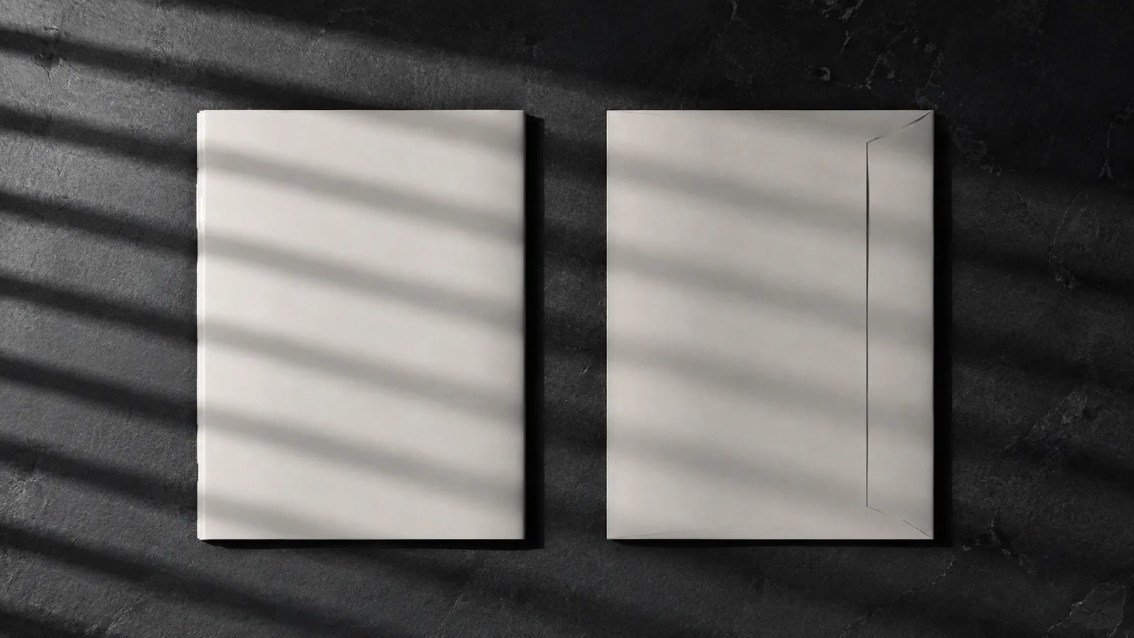 Two identical documents side by side on dark slate, lit by raking light